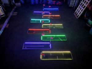 college kids having fun playing glow mini golf party rental